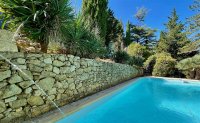 Entre les restanques de pierres, sous les palmiers une belle piscine privée. © VILLA L'OCCITANE