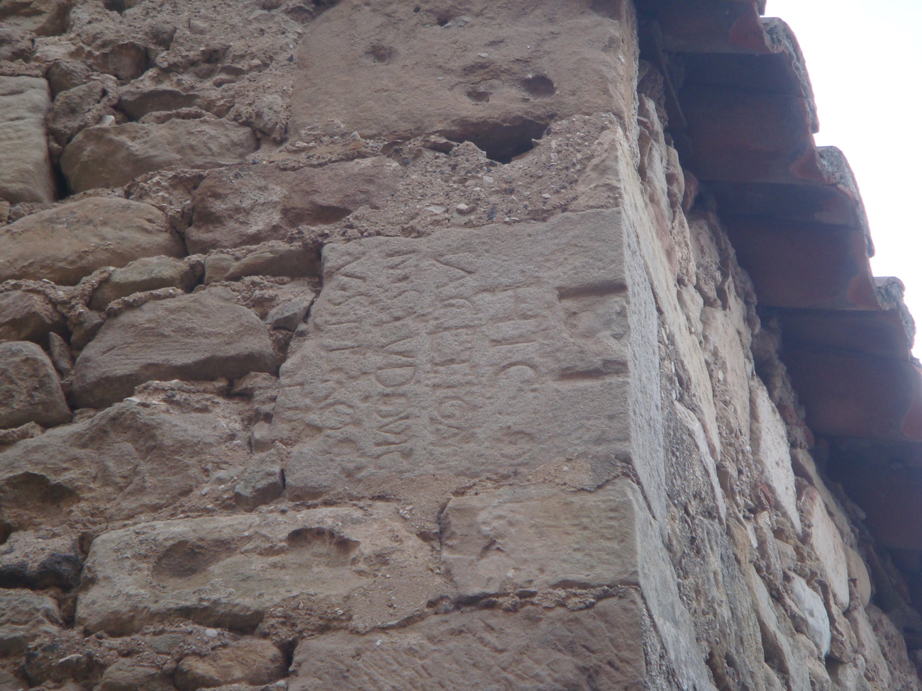 Vestige antique d&#039;une pierre inscrite réutilisée dans une construction plus tardive